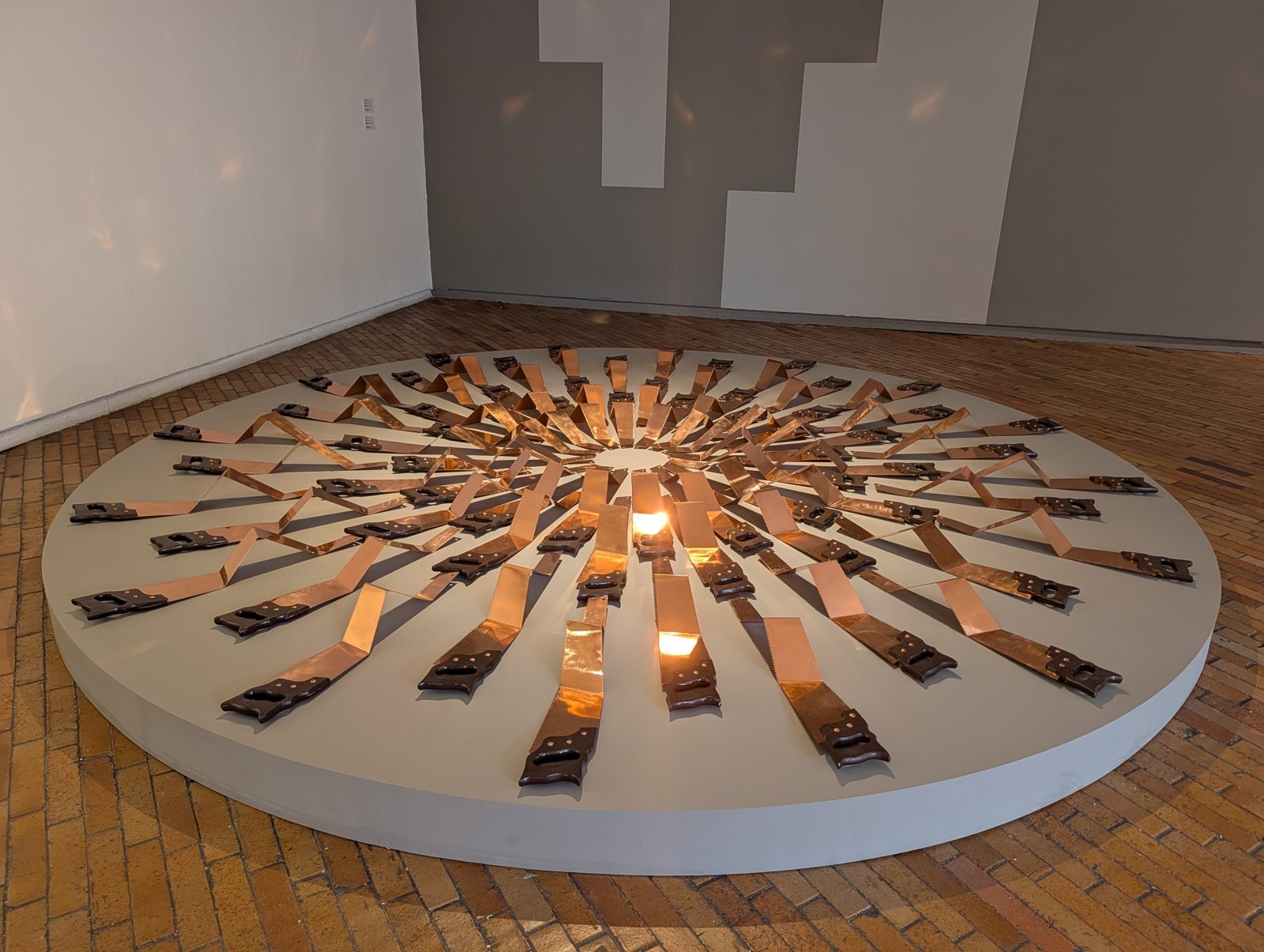 MAMBO. Copper strips laid out like a sunburst around a single flame, about what gets taken out of the ground here.