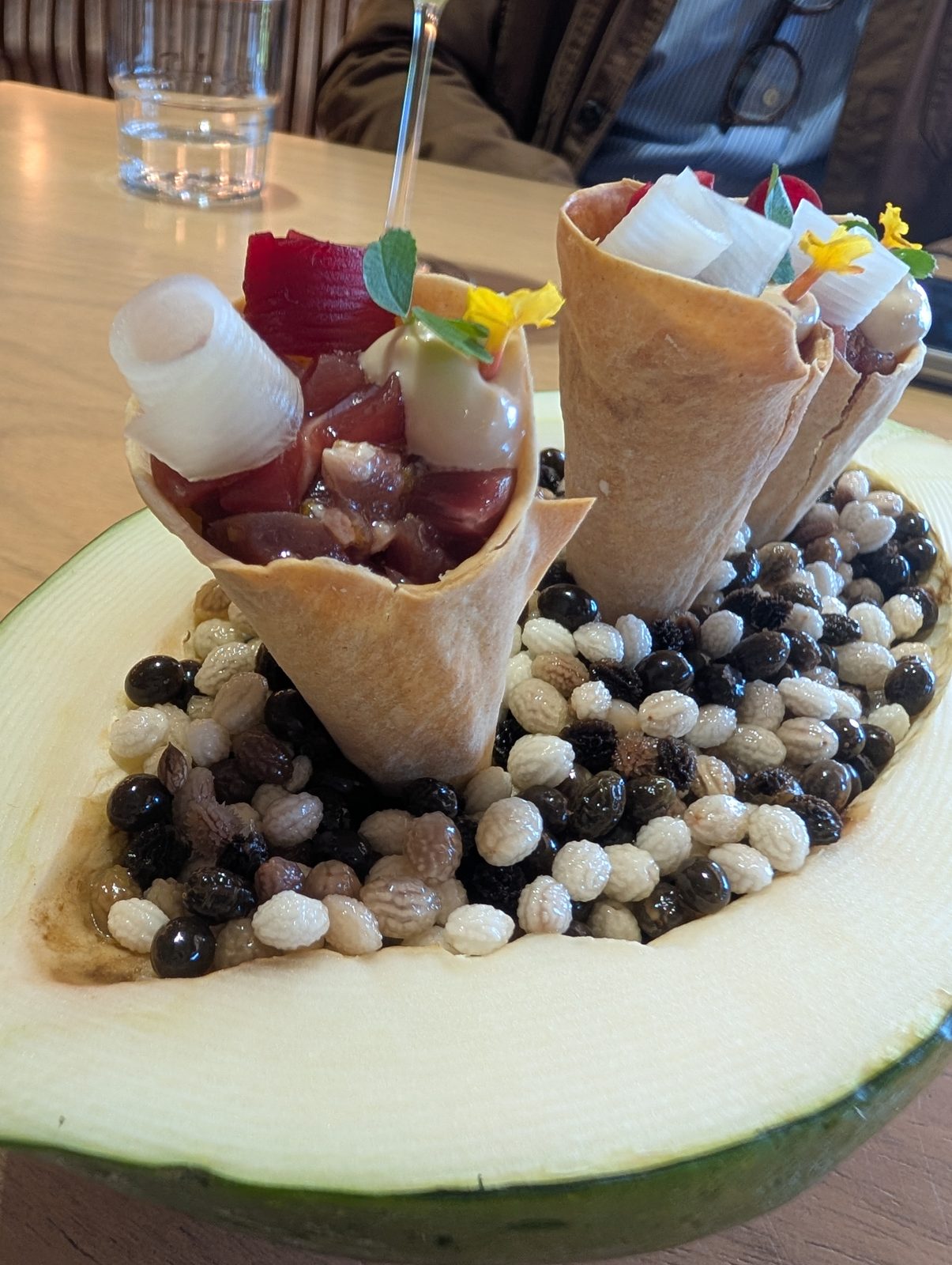 Cones standing in a melon, on a bed of Andean grains.