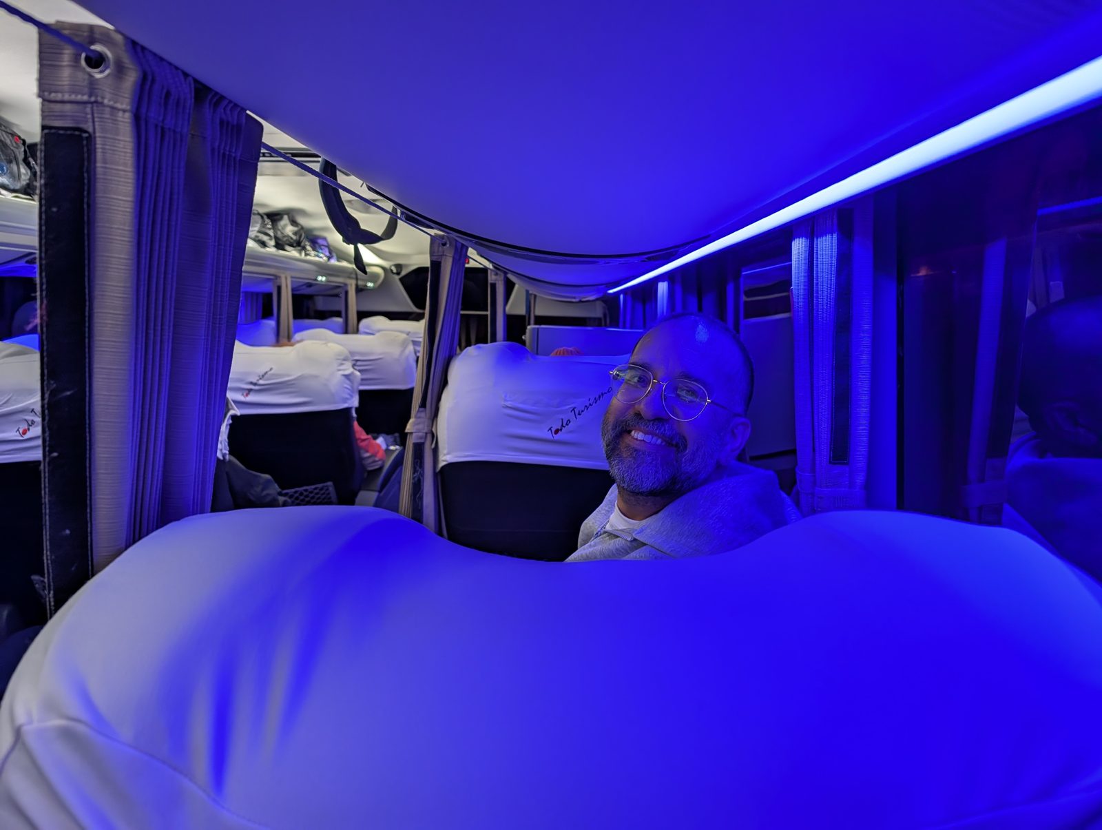 The night bus, in place of the flight that didn't exist. Juan, lit blue, before the road got rough.